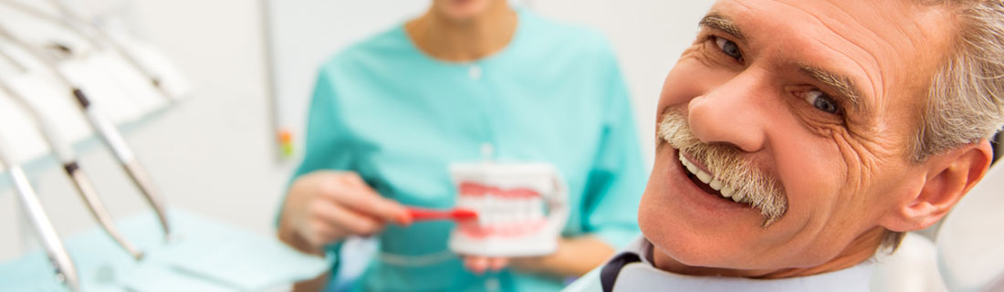 man-older-dentures-smiling-at-dentist.jpg