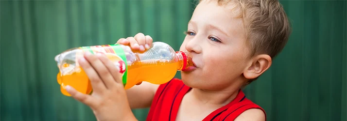 Young boy drinking sugary beverage emphasizing pediatric psychiatric care and healthy habits. Young boy drinking sugary beverage emphasizing pediatric psychiatric care and healthy habits.