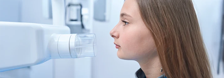 Young girl undergoing dental X-ray imaging at pediatric dentist, showcasing advanced diagnostic care.