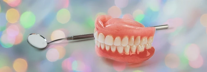A close up on a pair of dentures on a counter top alight with florescent spotting A close up on a pair of dentures on a counter top alight with florescent spotting