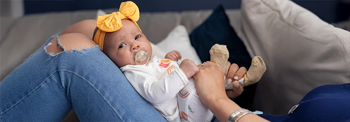 Baby relaxing with a pacifier after tongue-tie procedure, illustrating gentle pediatric dental aftercare. Baby relaxing with a pacifier after tongue-tie procedure, illustrating gentle pediatric dental aftercare.