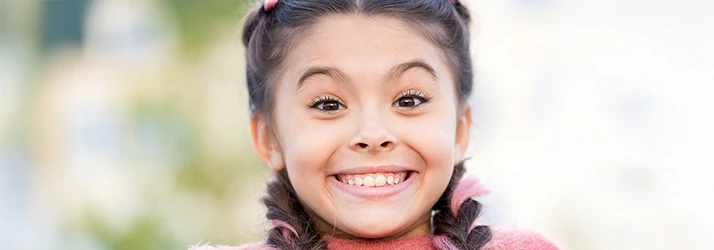 Smiling young girl after successful tongue-tie release procedure, highlighting pediatric dental care recovery. Smiling young girl after successful tongue-tie release procedure, highlighting pediatric dental care recovery.