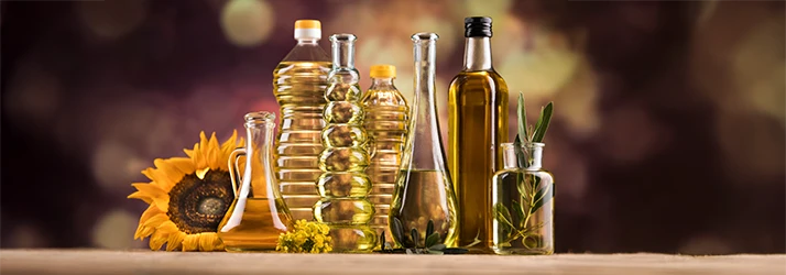 Various bottles of oils arranged with a sunflower, symbolizing oil pulling for children's natural oral health care. Various bottles of oils arranged with a sunflower, symbolizing oil pulling for children's natural oral health care.