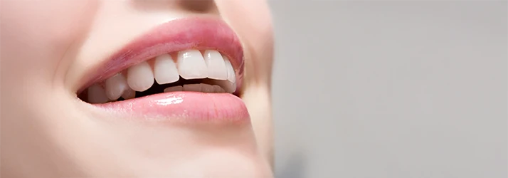 Close-up of a woman's perfect smile with straight, white teeth after orthodontic smile makeover. Close-up of a woman's perfect smile with straight, white teeth after orthodontic smile makeover.