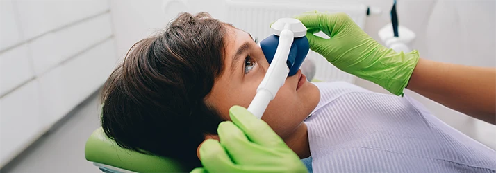 Child receiving pain-free sedation dentistry treatment using nitrous oxide at pediatric dental clinic. Child receiving pain-free sedation dentistry treatment using nitrous oxide at pediatric dental clinic.
