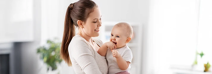 Mother comforting baby experiencing teething discomfort, illustrating pediatric dentistry teething support. Mother comforting baby experiencing teething discomfort, illustrating pediatric dentistry teething support.