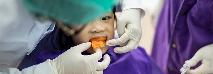 Child receiving silver diamine fluoride treatment at pediatric dental office, focusing on cavity prevention. Child receiving silver diamine fluoride treatment at pediatric dental office, focusing on cavity prevention.