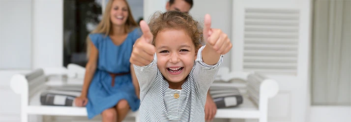 Smiling girl giving thumbs-up after successful pediatric dental treatment for oral trauma.