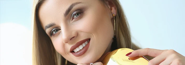 Smiling woman showcasing results of facial cosmetic oral surgery. Smiling woman showcasing results of facial cosmetic oral surgery.