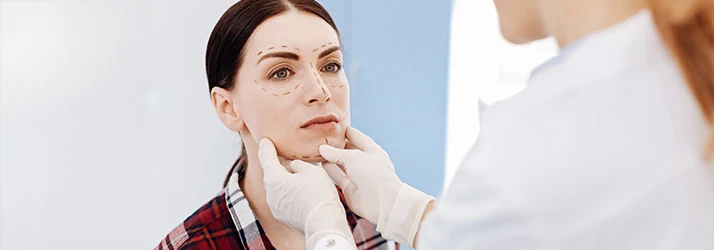 Surgeon marking patient's face before precise facial reconstruction oral surgery. Surgeon marking patient's face before precise facial reconstruction oral surgery.