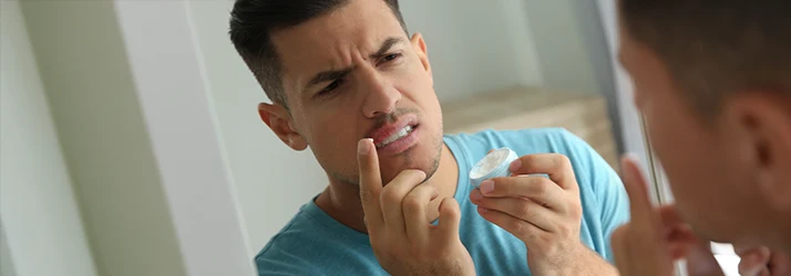 Man examining oral lesion, indicating the need for oral pathology assessment and surgery. Man examining oral lesion, indicating the need for oral pathology assessment and surgery.
