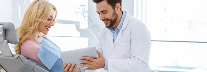 Periodontist discussing advanced periodontal disease management with patient. Periodontist discussing advanced periodontal disease management with patient.