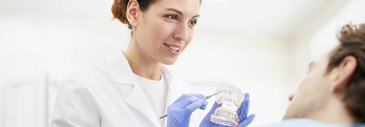 Periodontist explaining laser gum surgery treatment to patient. Periodontist explaining laser gum surgery treatment to patient.