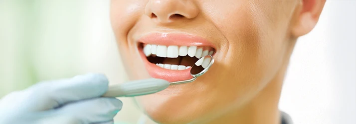 Close-up of patient receiving preventive periodontal care and dental examination from a periodontist to maintain healthy teeth and gums.