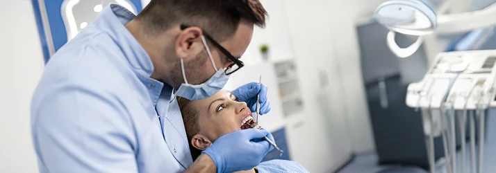Periodontist performing scaling and root planing treatment on a patient to improve gum health in a professional dental clinic.