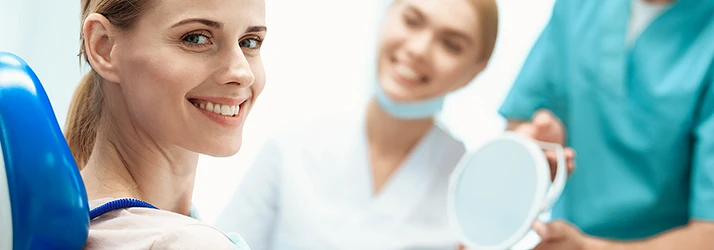 Smiling female patient feeling comfortable and relaxed in dental chair after sedation dentistry procedure at periodontist's office. Smiling female patient feeling comfortable and relaxed in dental chair after sedation dentistry procedure at periodontist's office.