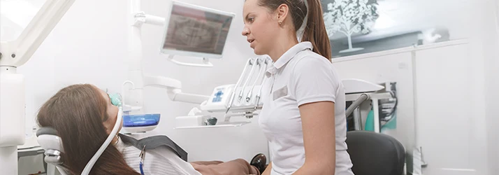 Periodontist comforting patient undergoing sedation dentistry for anxiety-free periodontal treatment in a modern dental clinic.