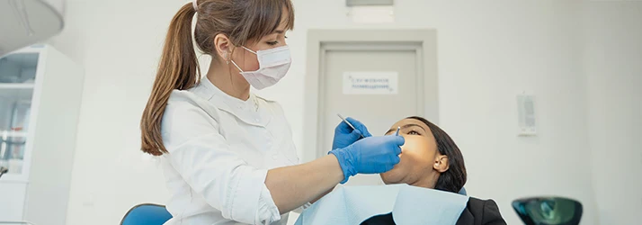 Periodontist performing professional teeth cleaning on a patient to maintain oral hygiene and gum health.
