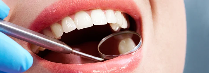 Close-Up-Of-A-Dental-Mirror-Being-Used-To-Examine-Patients-Mouth.webp