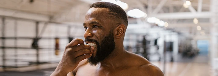 Man-Putting-A-Mouthguard-In-His-Mouth.webp