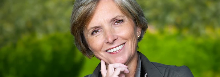 Woman-With-Veneers-Smiling-Outdoors-In-Nature.webp